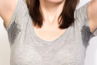 Frau mit Schweißflecken: Wer ein zuverlässiges Mittel gegen Schweiß sucht, sollte zu einem Antitranspirant greifen.