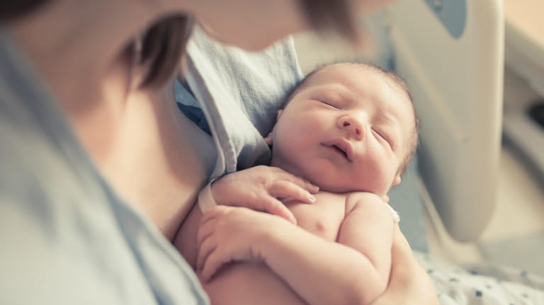 Mutter mit Neugeborenem im Arm: Babys wecken Beschützerinstinkte.
