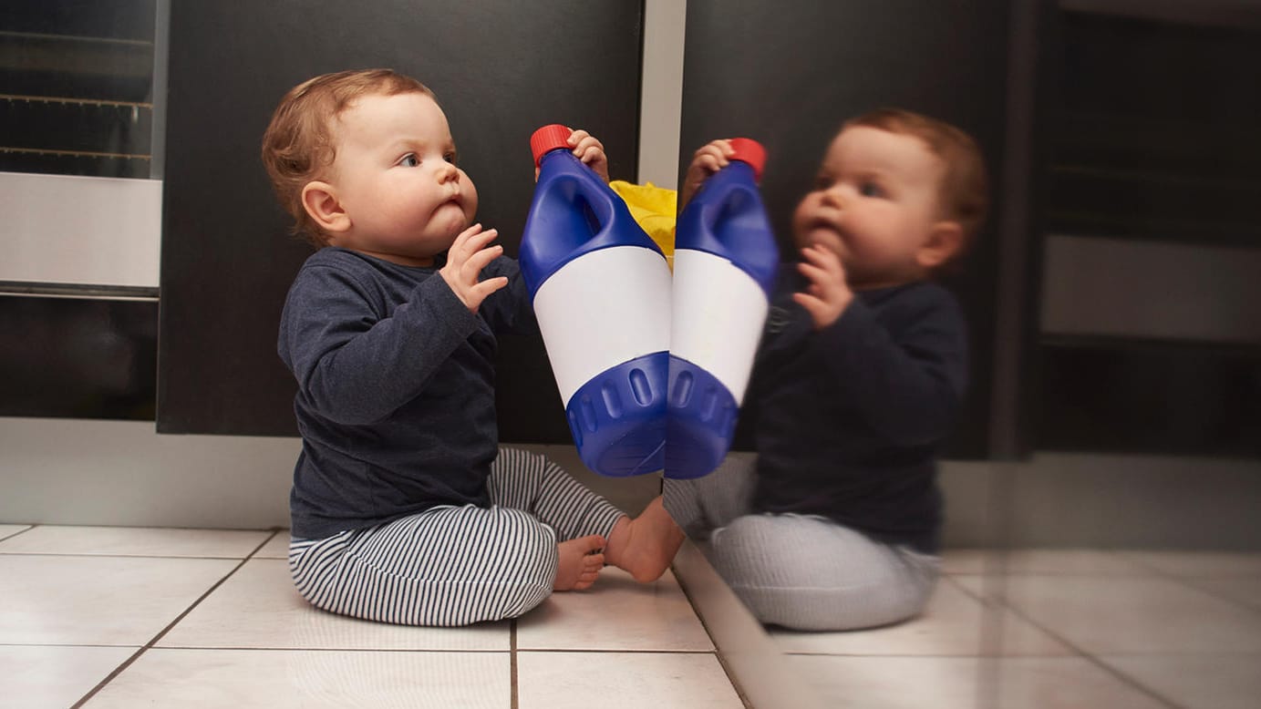 Kind mit Spülmittelflasche