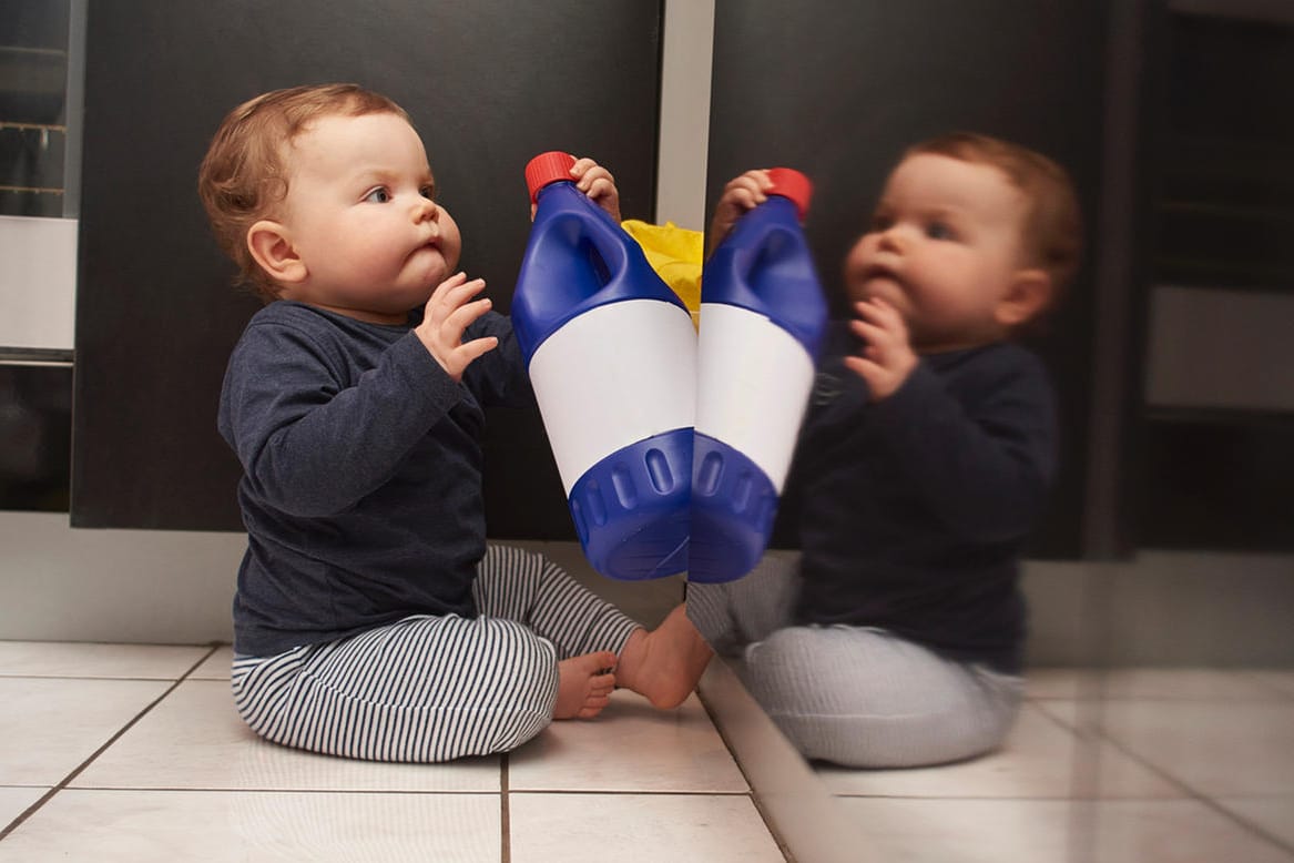 Kind mit Spülmittelflasche