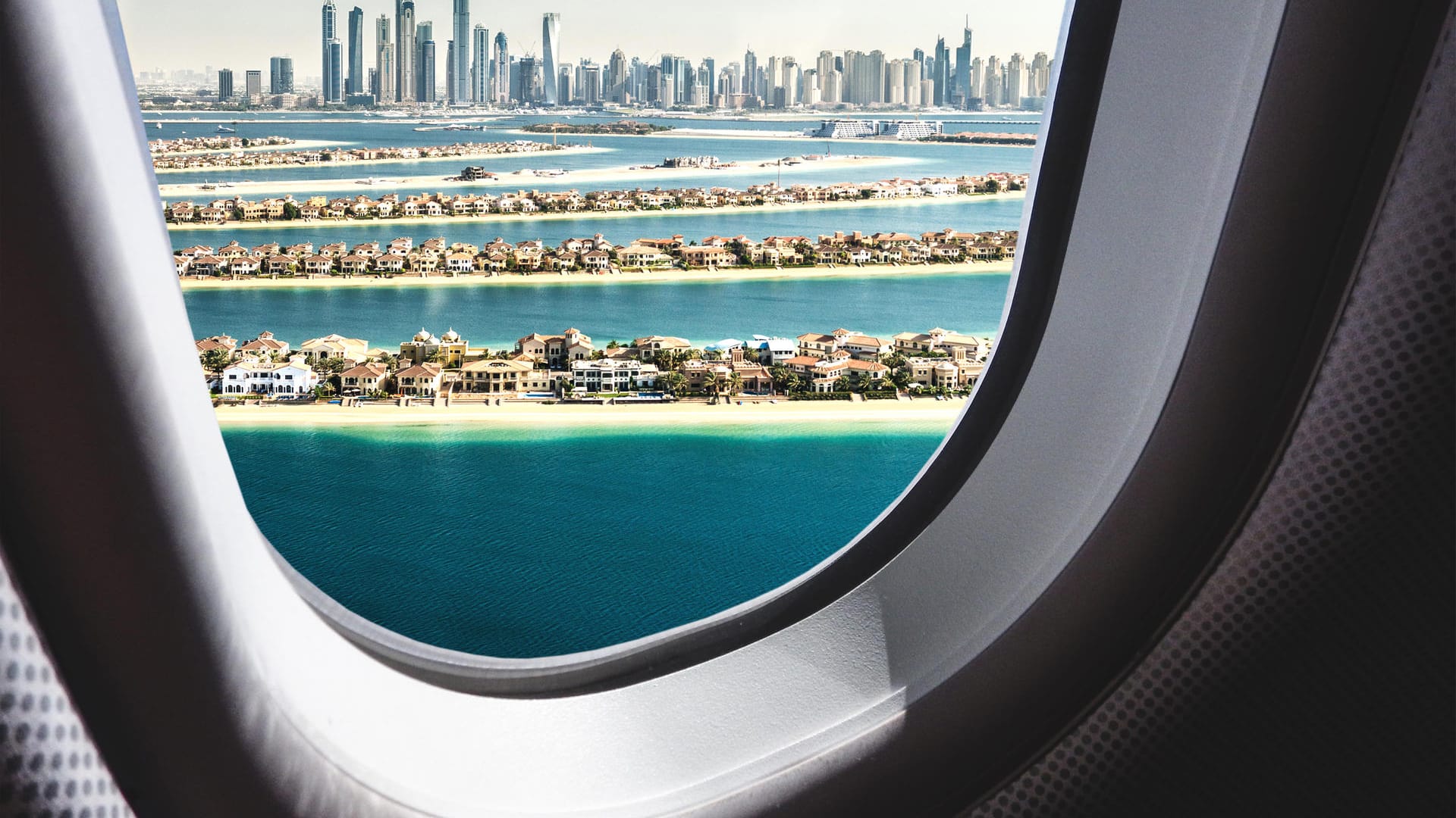 Ausblick aus dem Flugzeugfenster auf die Skyline von Dubai: Künstliche Inseln reihen sich vor den höchsten Wolkenkratzern der Welt.