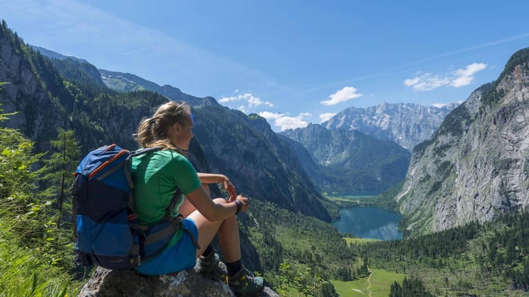 Nationalpark Berchtesgaden: Keine Sennerin, sondern eine Touristin ruht sich auf dem Röthsteig aus – mit Blick auf den Obersee und Königssee.