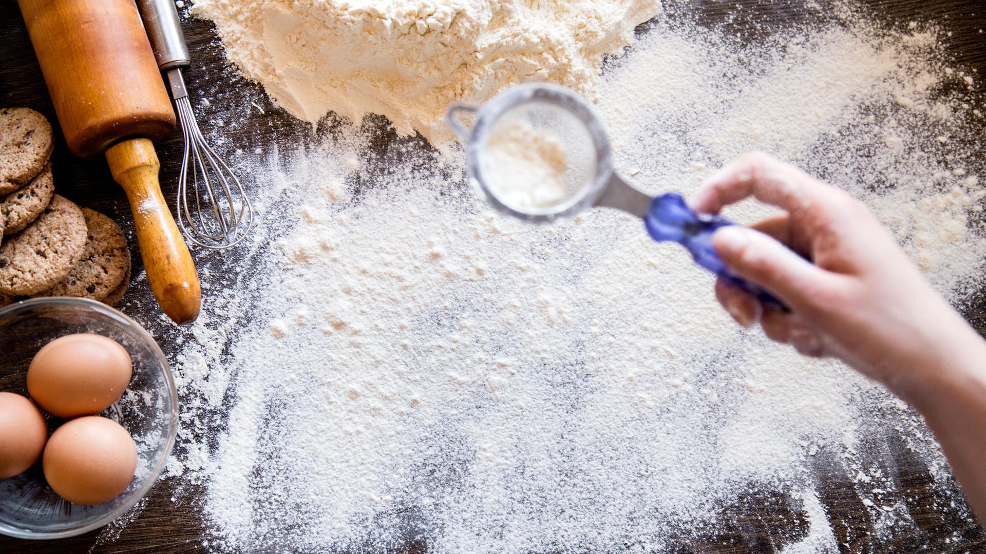 Plätzchen backen: Streuen Sie zum Ausrollen des Plätzchenteigs nur wenig Mehl auf die Arbeitsfläche – sonst werden die Plätzchen trocken.