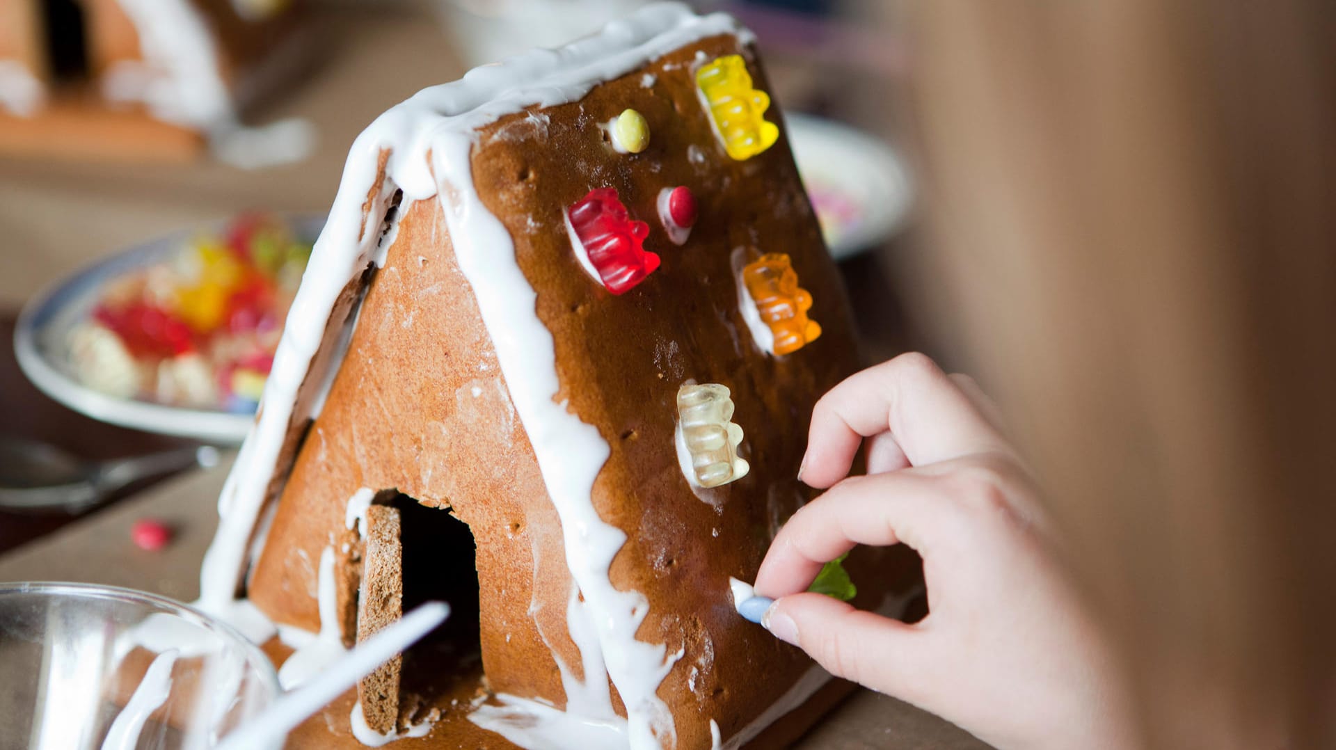 Mit Zuckerguss hält fast alles: Sie können das Lebkuchenhaus am Schluss mit Gummibärchen oder Schokolinsen verzieren.