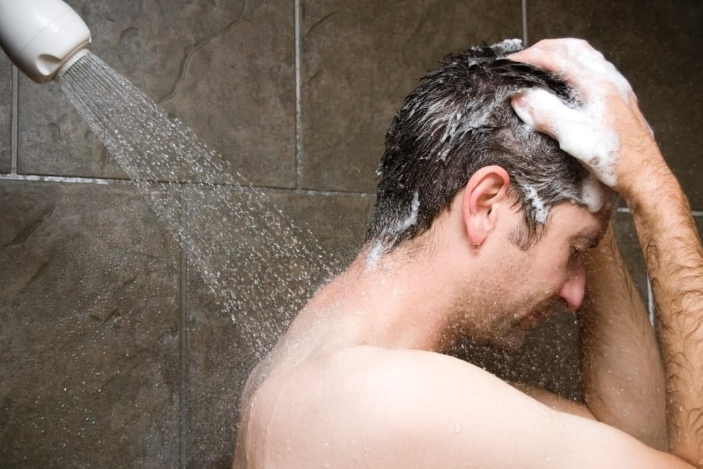 Ein Mann steht unter der Dusche (Symbolfoto): Gehören Warmwasser-Duschen bald der Vergangenheit an?