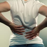 Hände an einer schmerzhaften Stelle: Rückenschmerzen können quälend sein, lassen sich aber meistens gut behandeln.