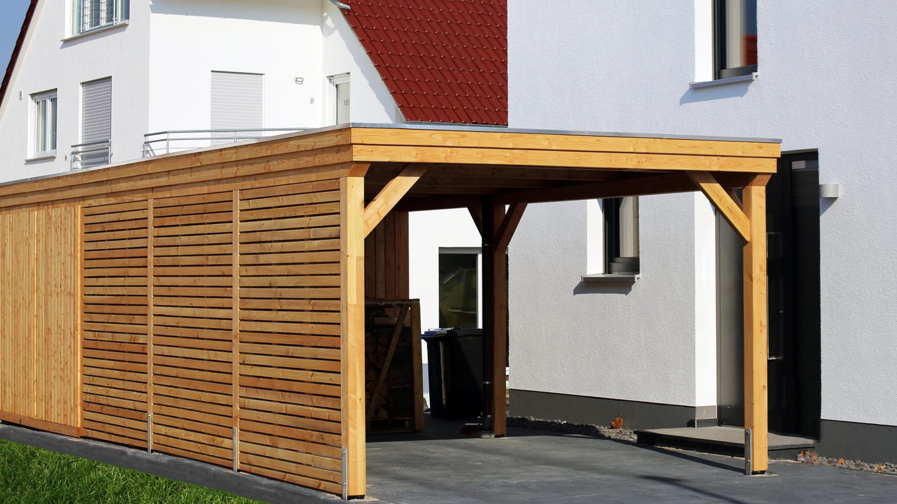 Carport aus Holz: Seitenwände schützen Ihr Fahrzeug sowie Ihre Mülltonnen zusätzlich vor Witteruntsbedingungen.