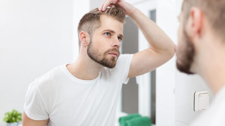 Der erste Haarausfall zeigt sich bei Männern oft in Geheimratsecken.