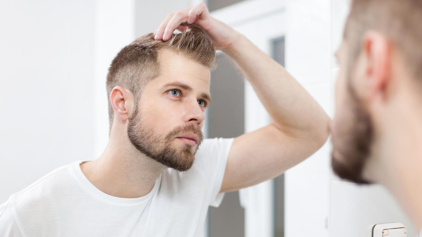 Der erste Haarausfall zeigt sich bei Männern oft in Geheimratsecken.