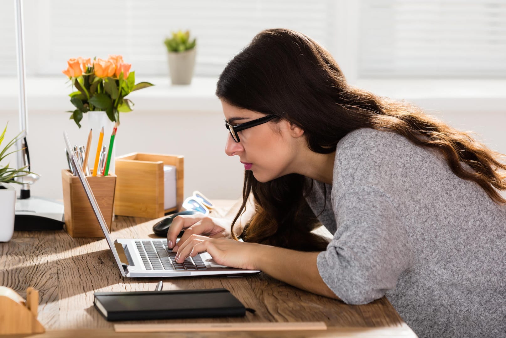 Eine Frau beugt sich über ihren Laptop: Was steckt hinter der Fehlermeldung "Netzwerk-Zeitüberschreitung"?