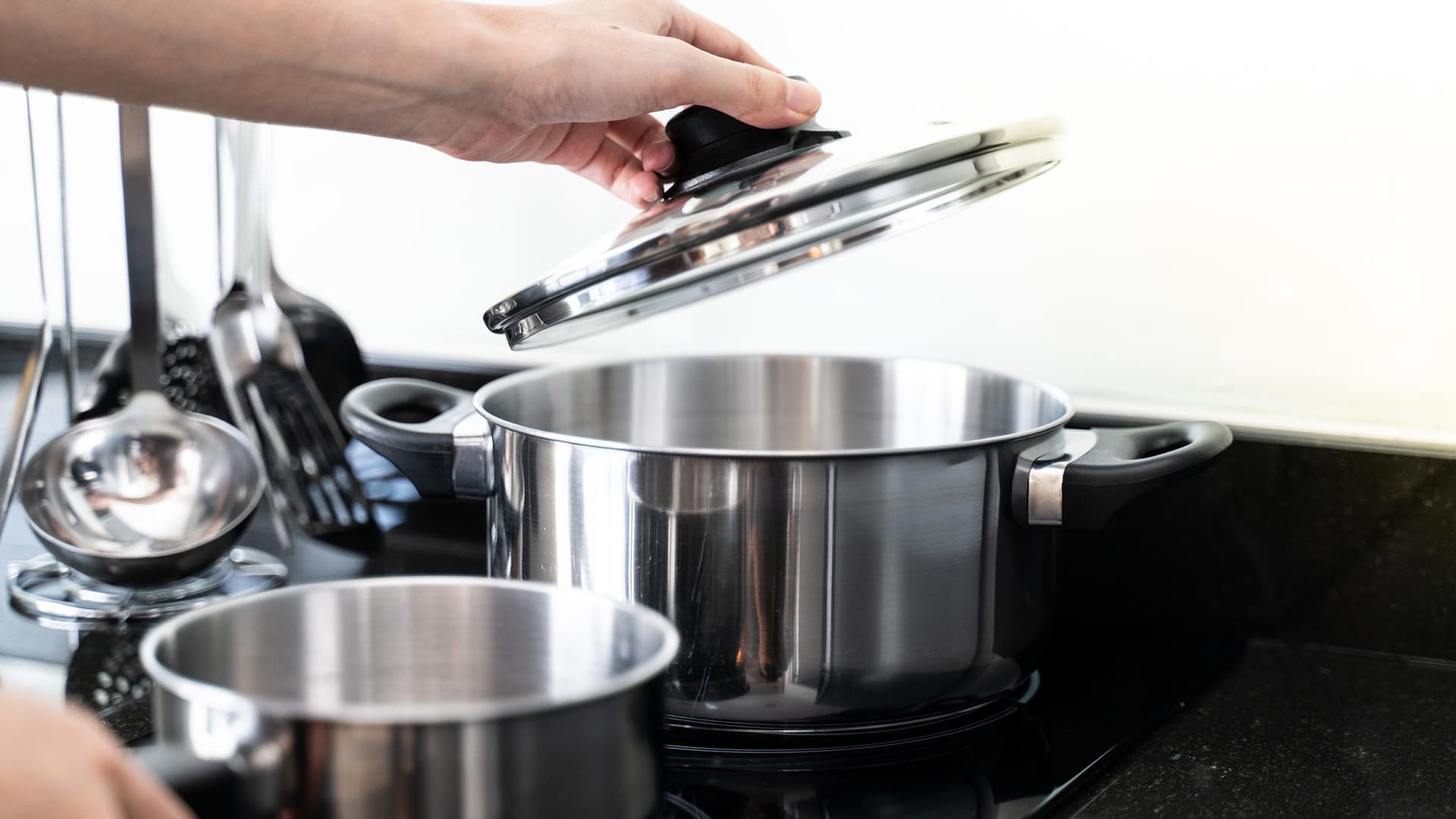 Töpfe auf einem Herd: Mit einem Deckel auf dem Topf sparen Sie beim Kochen Energie.