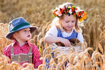 Kinder in bayerischer Tracht auf dem Feld: In Bayer erhalten Eltern für das zweite und dritte Lebensjahr ihres Kindes Familiengeld.