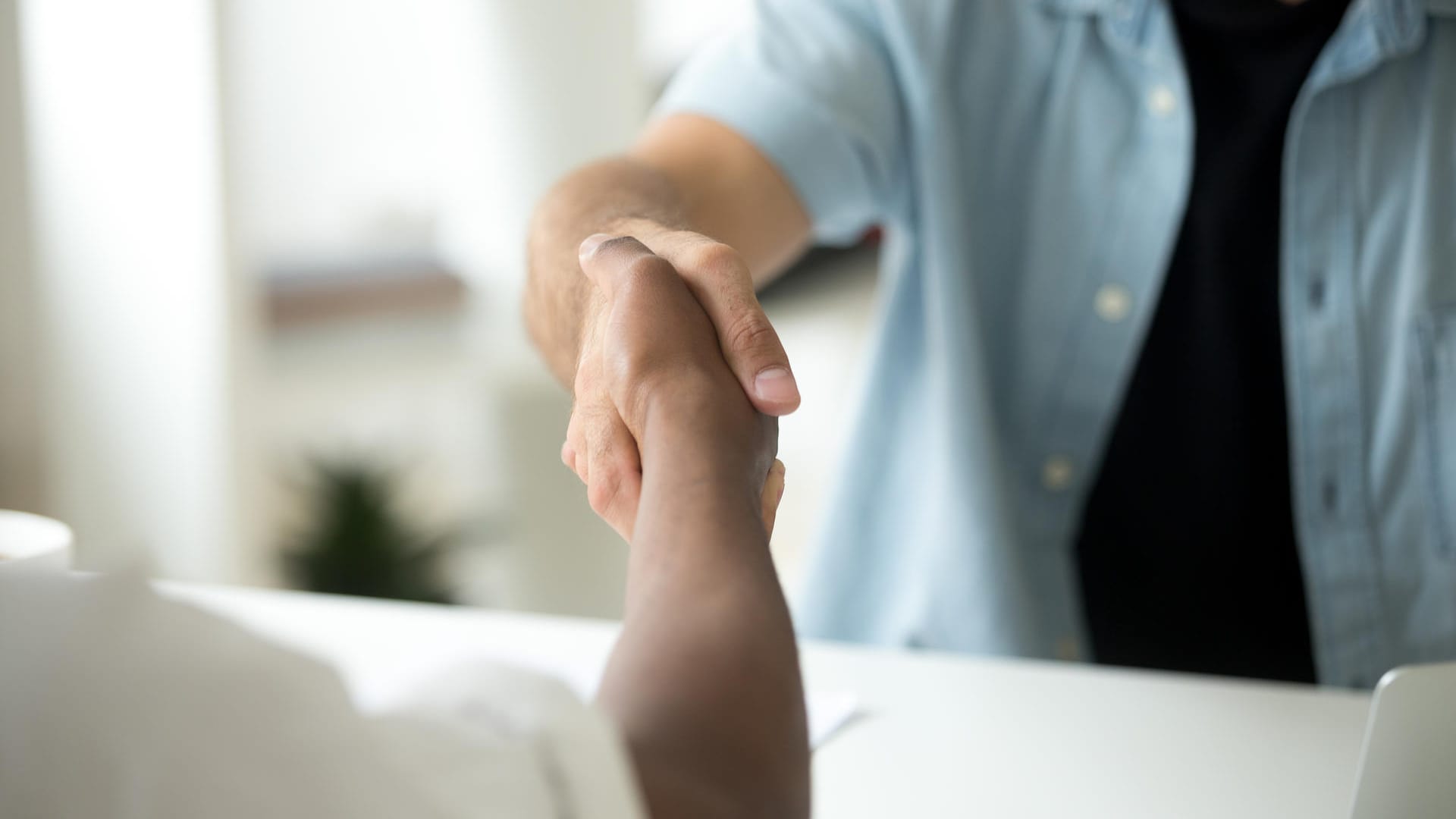 Zwei Männer geben sich die Hand: Vermeiden Sie Kontakt auch bei der Begrüßung.