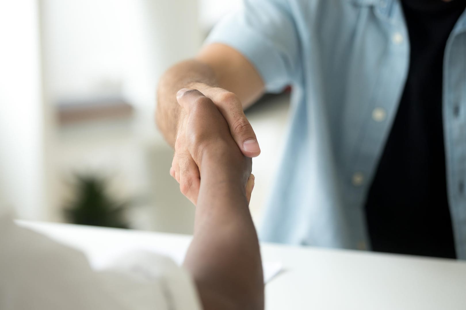 Zwei Männer geben sich die Hand: Vermeiden Sie Kontakt auch bei der Begrüßung.