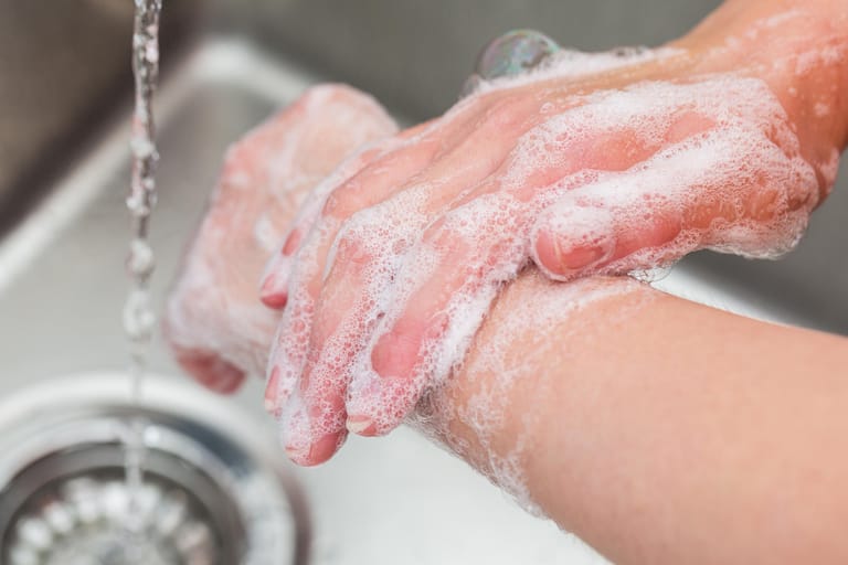 Jemand wäscht sich die Hände: Waschen und desinfizieren Sie sich regelmäßig die Hände.