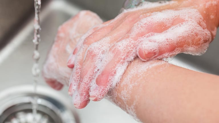 Jemand wäscht sich die Hände: Waschen und desinfizieren Sie sich regelmäßig die Hände.
