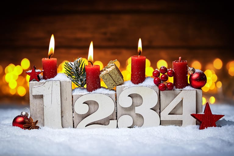 Adventskerzen in nummerierten Kerzenständern: Moderne Adventskränze sind minimalistisch. Simpel, aber schick ist diese Kombination aus Holzkerzenständern und roten Kerzen. Ein wenig Schneespray dazu – und fertig ist der moderne Adventsschmuck, der in jede Wohnungseinrichtung passt.
