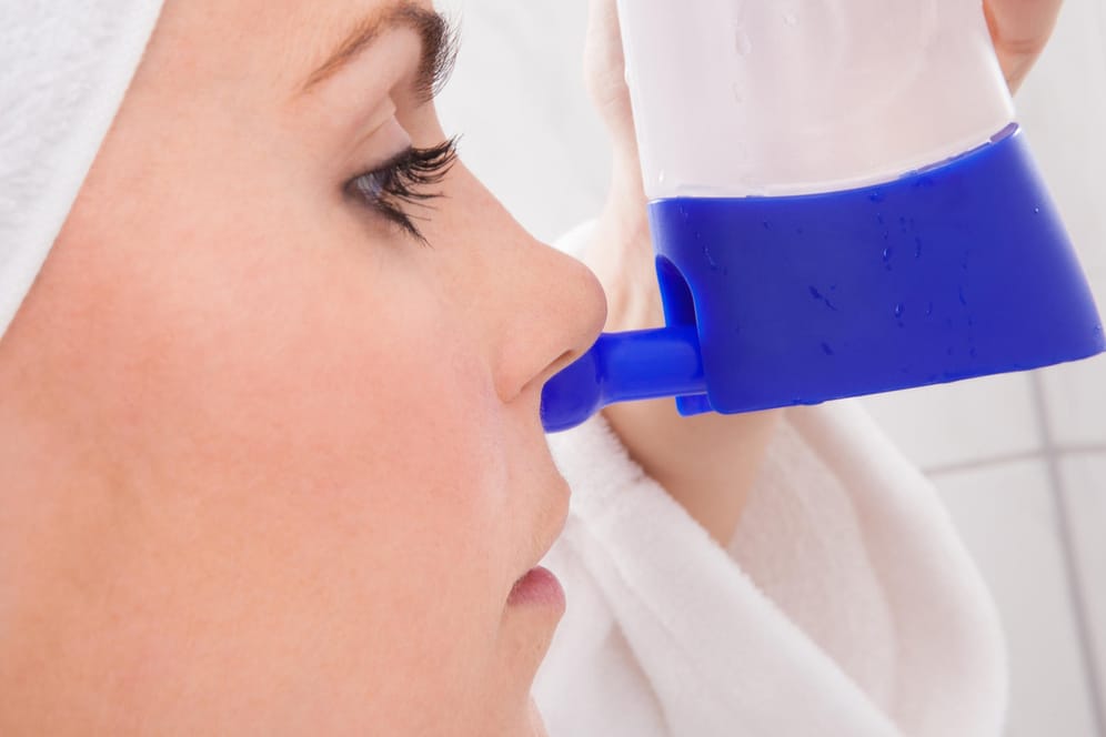 Junge Frau nutzt die Nasendusche: Nasenspülungen können Erkältungsbeschwerden lindern.