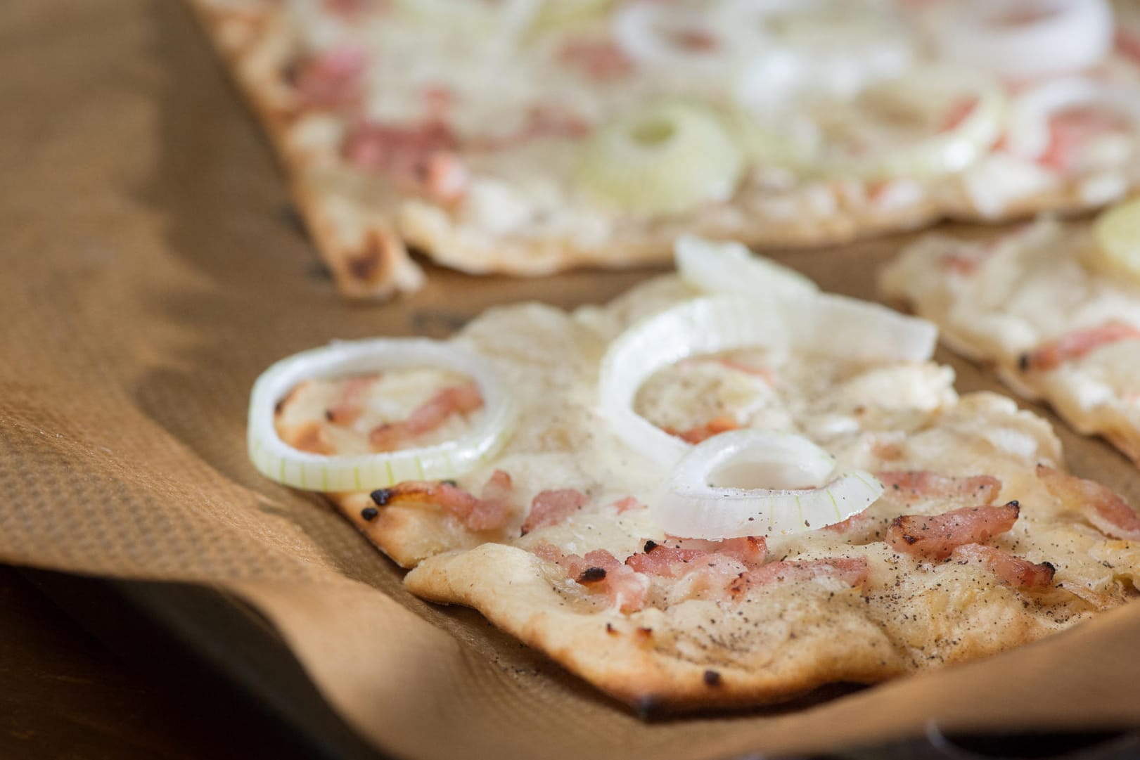 Flammkuchen: Der Klassiker wird mit Zwiebeln und Speck belegt.