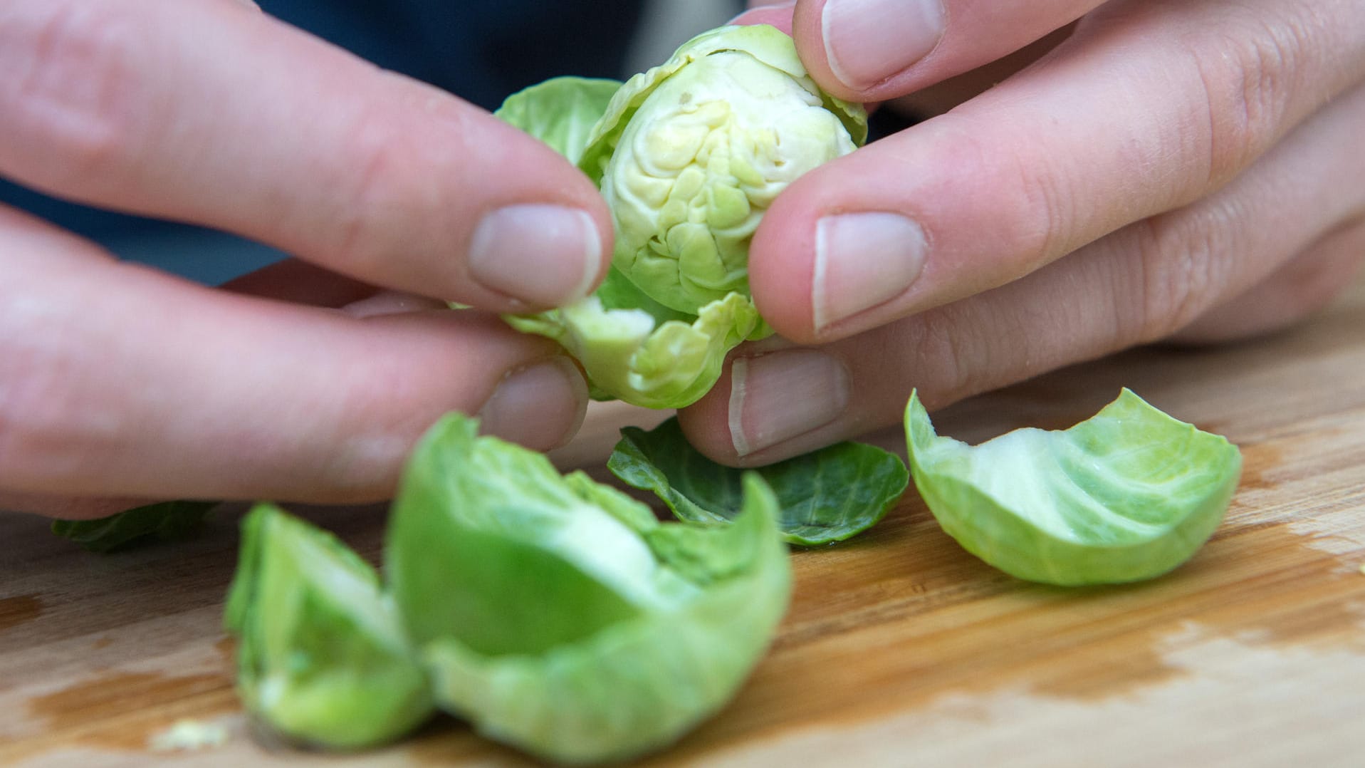 Rosenkohl: Wer nur die Blätter blanchieren möchte, löst sie am besten mit den Fingern vorsichtig ab.