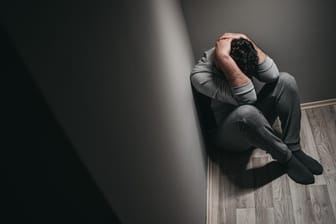 Ein Mann sitzt zusammengekauert in einer Ecke: Depressionen sind mehr als nur ein Phase der Niedergeschlagenheit.