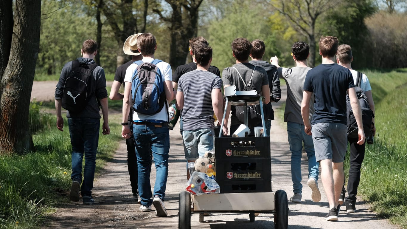 Männerpartie: Eine Gruppe junger Männer feiert den Vatertag mit einem mit Bier gefüllten Bollerwagen.