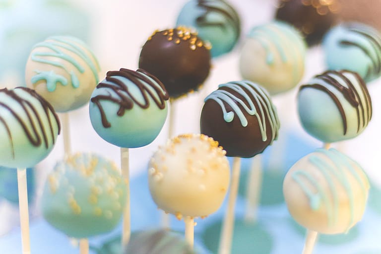 Cake-Pop bedeutet so viel wie "Kuchen-Lolli" und bezeichnet kleine Küchlein am Stiel. Sie werden aus einer Mischung aus fertigem Rührkuchenteig und sogenanntem Frosting geformt. Hierbei handelt es sich meist um eine Creme aus Frischkäse, die für den nötigen Halt sorgt. Zum Abschluss werden die kleinen Kugeln nach Herzenslust verziert – ob Schokolade, Streusel, Zuckerguss oder Marzipan, der Fantasie sind keine Grenzen gesetzt.