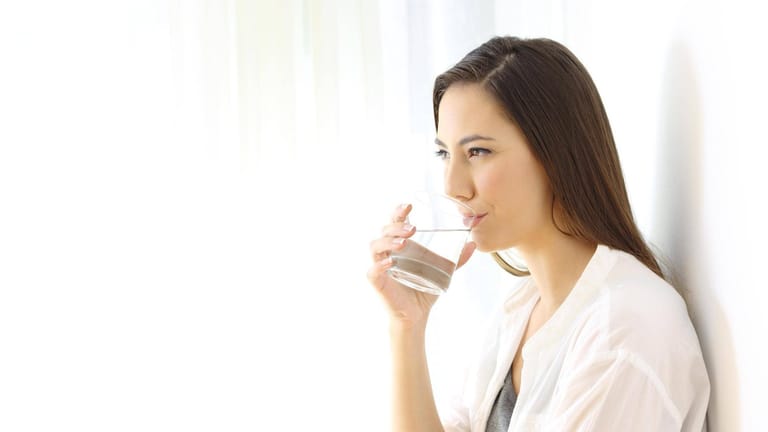 Glaubersalz: Junge Frau trinkt Wasser aus einem Glas.