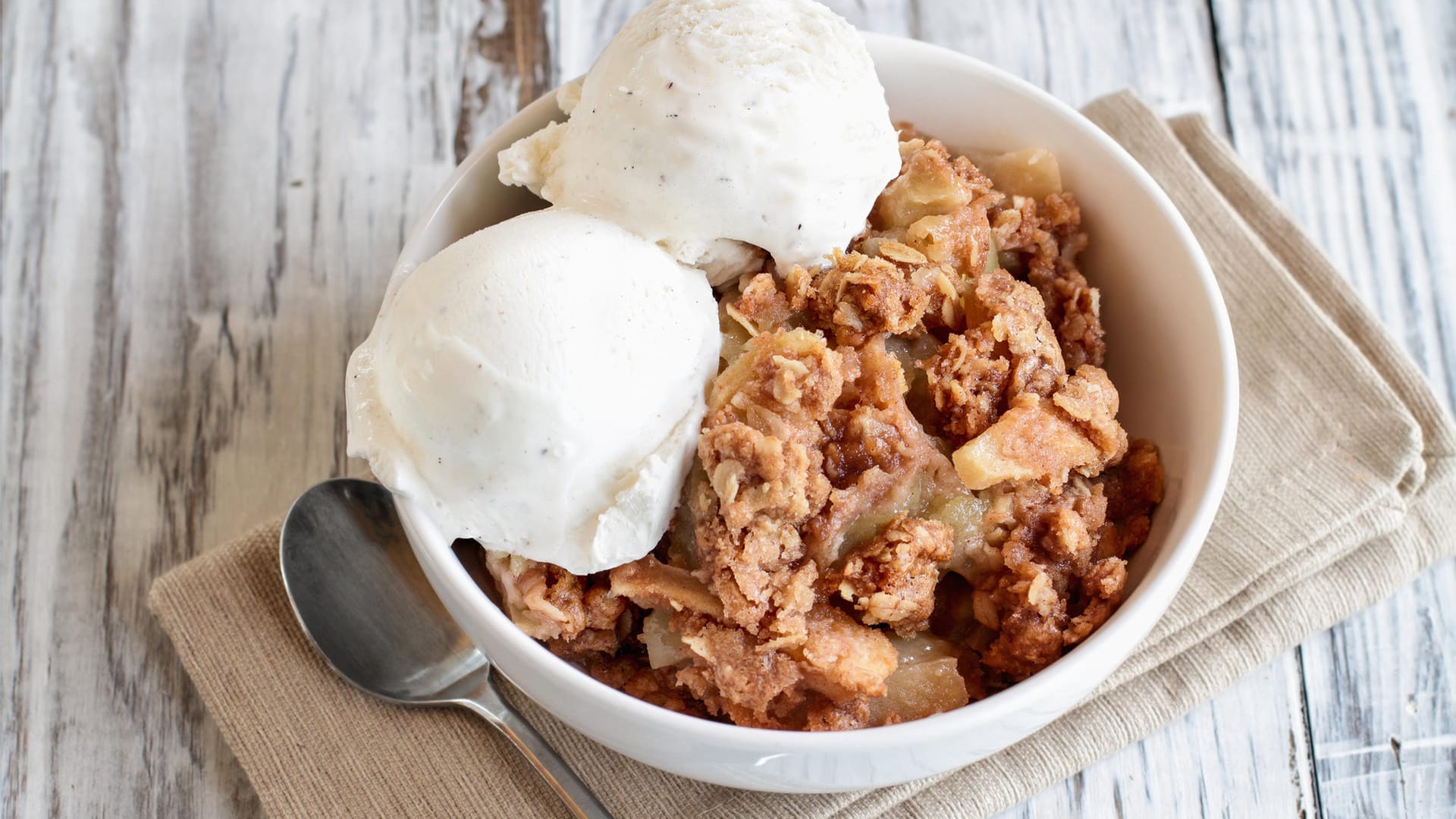 Crumble mit Vanilleeis: Frisch aus dem Ofen serviert schmeckt Apfel-Crumble besonders gut.