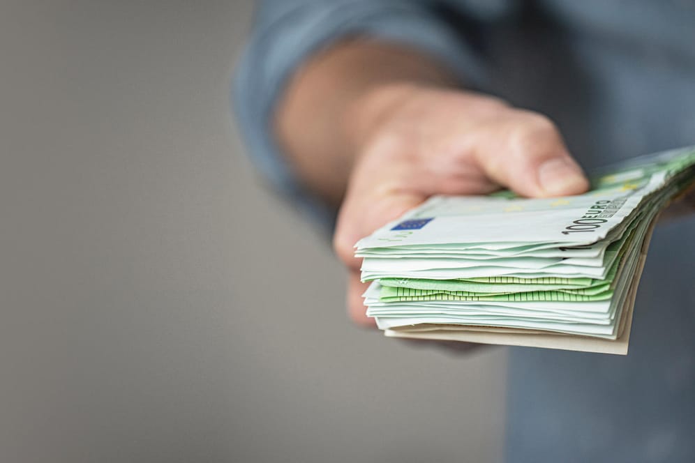 Ein Mann hält einen Stapel Euroscheine (Symbolbild): Festgeld bringt zwar keine enormen Erträge, ist aber allemal besser als Geldscheine unter dem Kopfkissen zu horten.