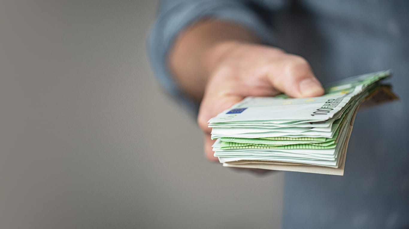 Ein Mann hält einen Stapel Euroscheine (Symbolbild): Festgeld bringt zwar keine enormen Erträge, ist aber allemal besser als Geldscheine unter dem Kopfkissen zu horten.