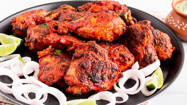 Tandoori Chicken: Zwischendurch wird das Fleisch immer wieder mit der Marinade bestrichen.