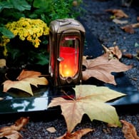Grave light with autumn leaves