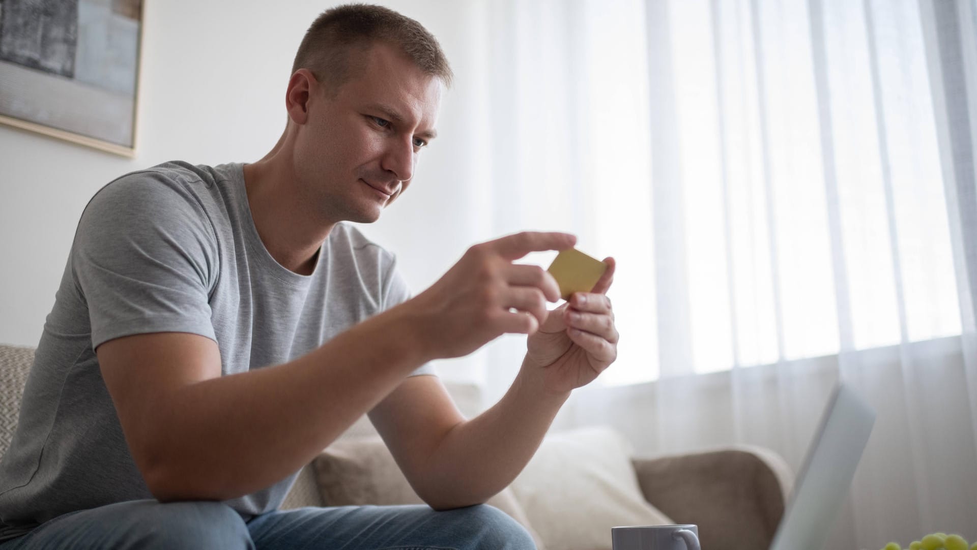 Mann mit Geldkarte in der Hand (Symbolbild): Eine Kündigung einer Kreditkarte muss schriftlich erfolgen.