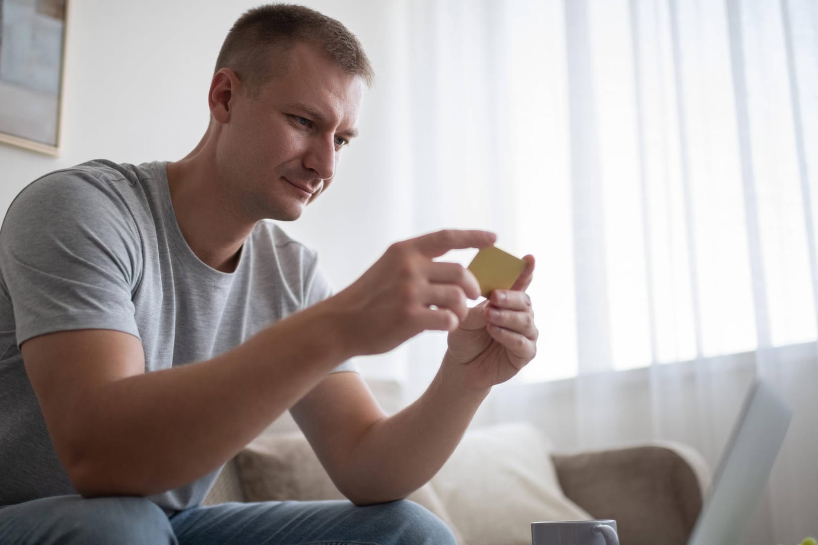 Mann mit Geldkarte in der Hand (Symbolbild): Eine Kündigung einer Kreditkarte muss schriftlich erfolgen.