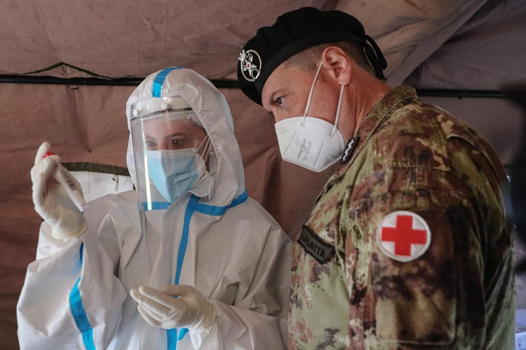 Ein italienischer Soldat und eine Ärztin: In Italien hat sich die Corona-Lage wieder deutlich zugespitzt. Das Land zählt mehr als 4,6 Millionen Infizierte. Mehr als 130.800 Menschen starben an Covid-19.