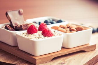 Schälchen mit Schokolade, Beeren und Mandeln