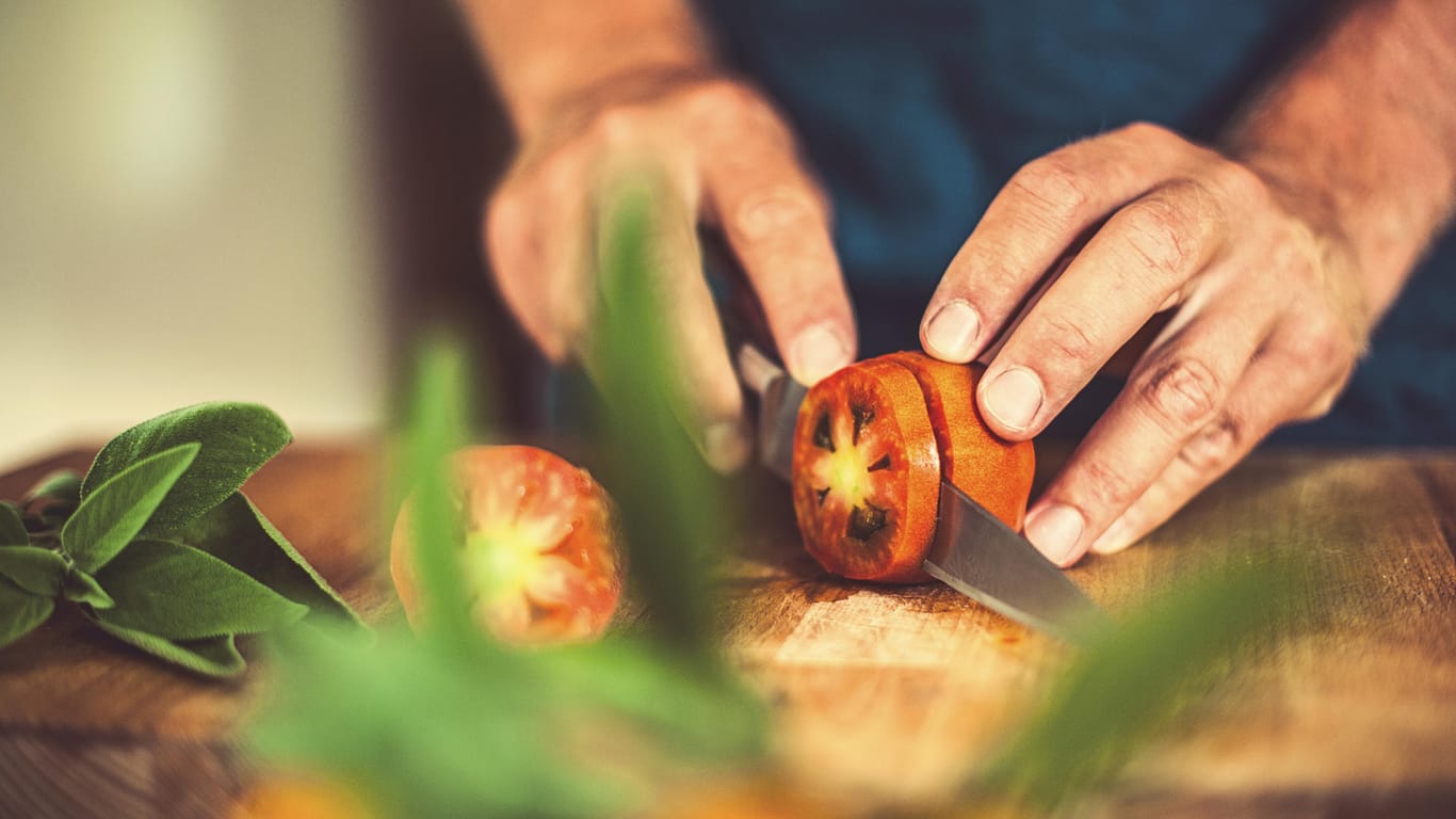 Tomaten schneiden: Scheiben gelingen am besten, wenn der Stielansatz beim Schneiden zur Seite zeigt.
