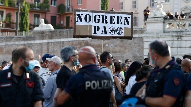 Demonstranten und Mitglieder der rechtsextremen Organisation Forza Nuova halten ein Schild mit der Aufschrift "No Green Pass" bei einem Protest gegen die Restriktionen des sogenannten Grünen Passes. Demonstranten und Mitglieder der rechtsextremen Organisation Forza Nuova halten ein Schild mit der Aufschrift "No Green Pass" bei einem Protest gegen die Restriktionen des sogenannten Grünen Passes.