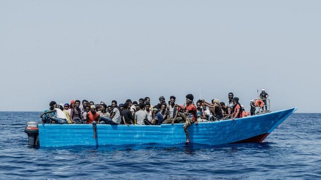 Menschen sitzen in einem Schlauchboot. Menschen sitzen in einem Schlauchboot.