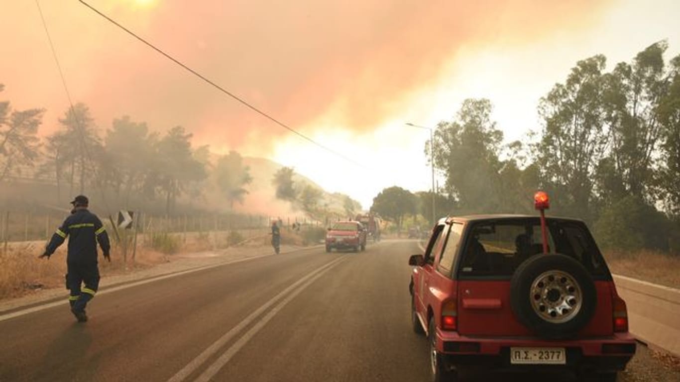 Feuerwehrleute bekämpfen einen Waldbrand in der Nähe des Dorfes Lampiri, westlich von Patras.