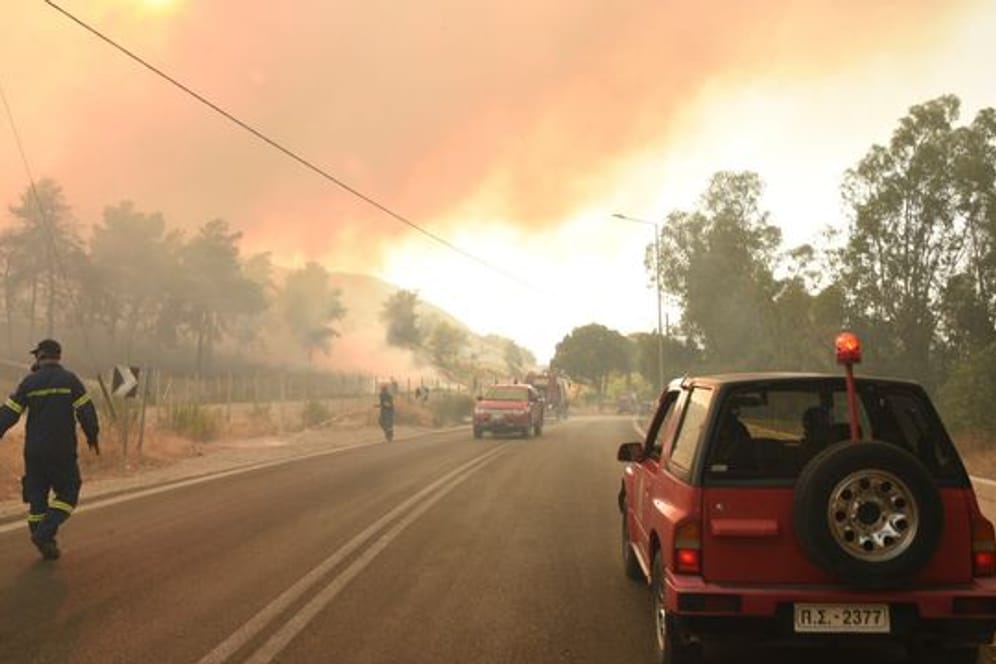 Feuerwehrleute bekämpfen einen Waldbrand in der Nähe des Dorfes Lampiri, westlich von Patras.