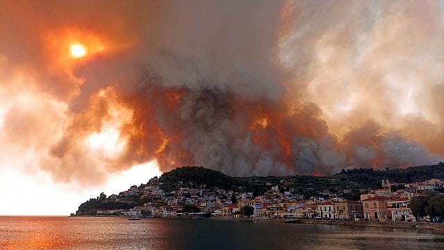 Rauch eines Waldbrandes steigt hinter einem Berghang in dem Ort Limni auf der Halbinsel Euböa etwa 160 Kilometer nördlich von Athen auf. Rauch eines Waldbrandes steigt hinter einem Berghang in dem Ort Limni auf der Halbinsel Euböa etwa 160 Kilometer nördlich von Athen auf.
