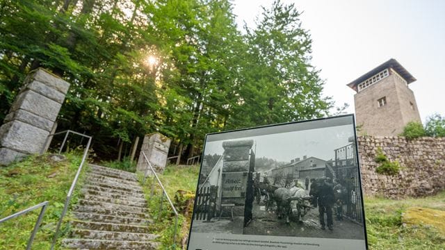 Eine Informationstafel steht auf dem Gelände der KZ-Gedenkstätte Flossenbürg vor einem ehemaligen Wachturm.