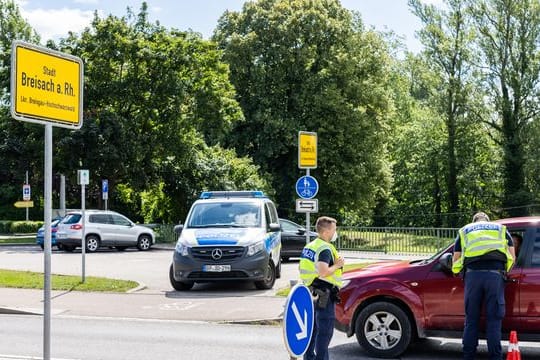 Beamte der Bundespolizei kontrollieren an der Rheinbrücke in Breisach aus Frankreich kommende Fahrzeuge.