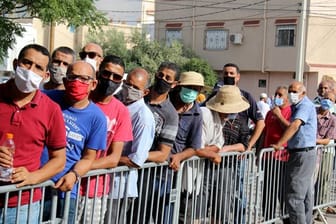 Zahlreiche Menschen stehen vor einem Impfzentrum im tunesischen Oued Ellil Schlange.