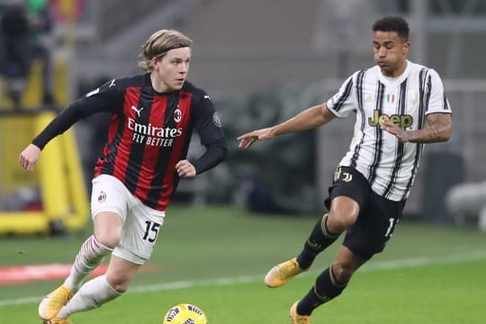 Milans Jens Petter Hauge und Juventus Danilo liefern sich ein Duell um den Ball.