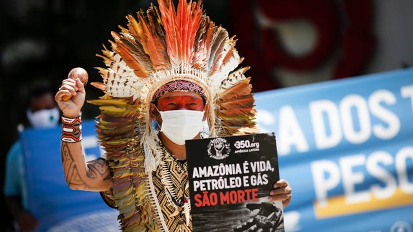 Ninawa Inu Huni kui hält ein Schild mit der Aufschrift "Amazonen ist Leben, Öl und Gas sind Tod" während eines Protests gegen Auktionen zur Erkundung von Ölfeldern in den Amazonen vor einem Hotel in Rio de Janeiro.