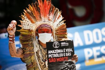 Ninawa Inu Huni kui hält ein Schild mit der Aufschrift "Amazonen ist Leben, Öl und Gas sind Tod" während eines Protests gegen Auktionen zur Erkundung von Ölfeldern in den Amazonen vor einem Hotel in Rio de Janeiro.
