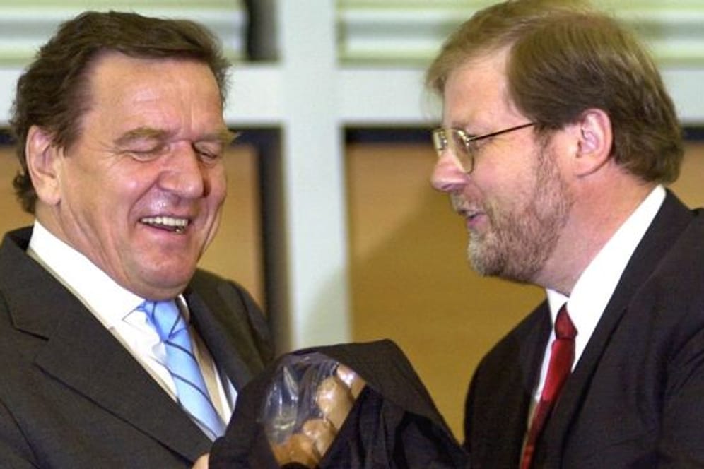 2002 erhält Gerhard Schröder (l) Currywürste von Hans-Jürgen Uhl, dem damaligen Geschäftsführer des Gesamt- und Konzernbetriebsrates von VW.